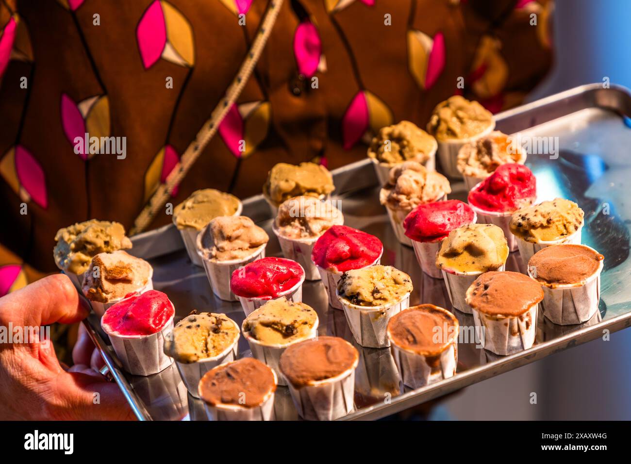 Un cameriere trasporta un vassoio con circa due dozzine di piccole coppe di gelato ai gusti vari, comprese porzioni rosso vivo, attraverso le strade di Södermalm. Il gelato proviene da Stikki Nikki ed è parte di una degustazione durante un tour gastronomico. Skanstull, Södermalm, Stoccolma, Contea di Stoccolma, Svezia. Foto Stock
