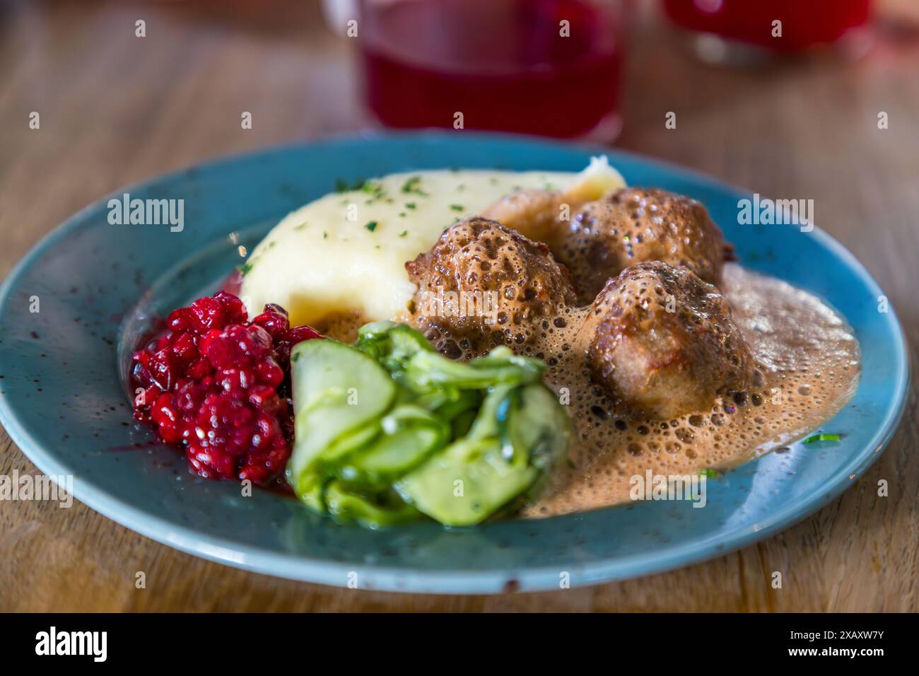 Il classico svedese Köttbollar si trova con purè di patate cremoso, insalata di cetrioli e mirtilli rossi su un piatto blu al ristorante Meatballs for the People a Södermalm, Stoccolma. Le polpette qui sono fatte di maiale, manzo, agnello o selvaggina. Kocksgatan 33–37, Södermalm, Stoccolma, Contea di Stoccolma, Svezia. Foto Stock