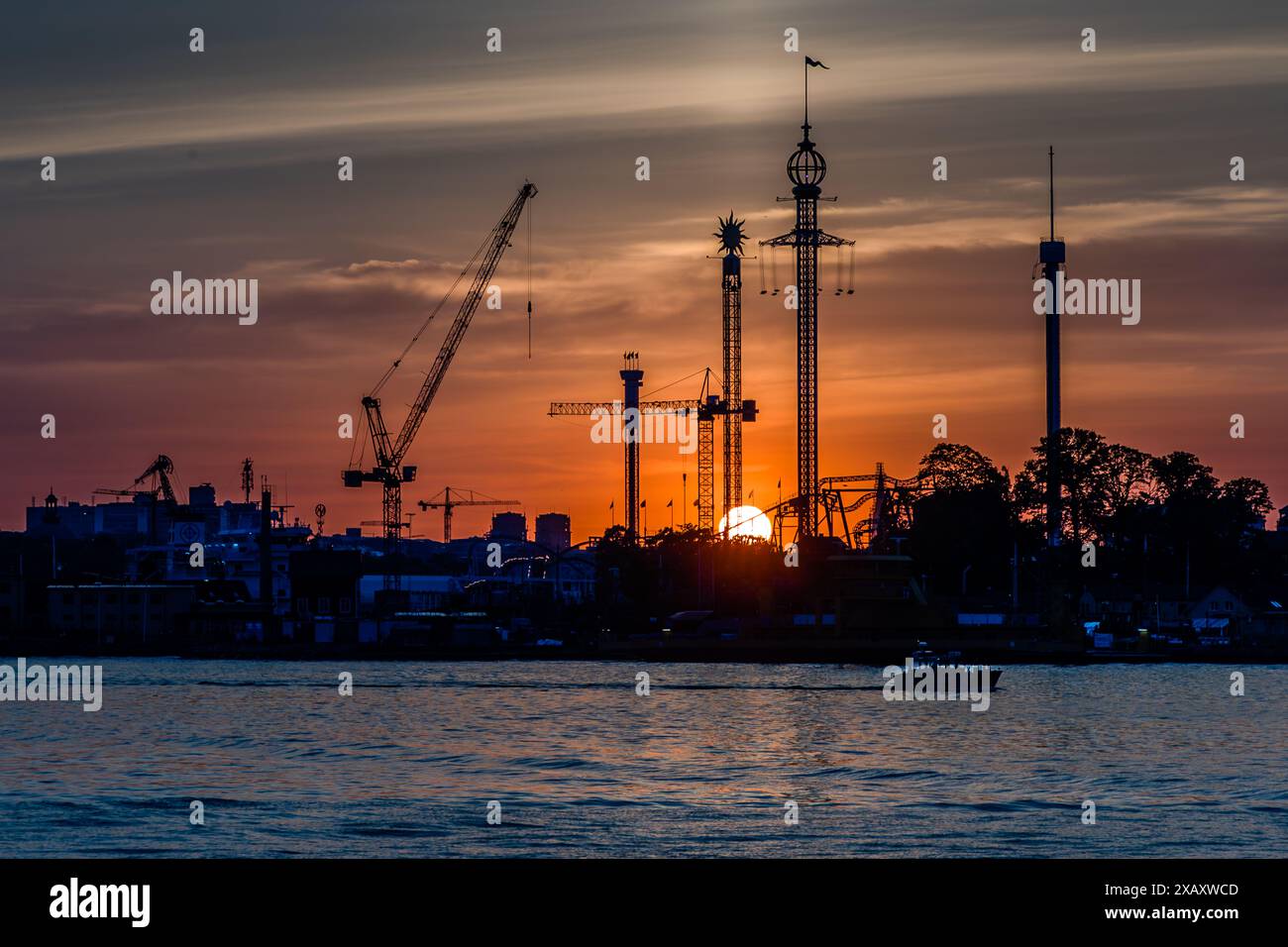 Gröna Lund sull'isola di Djurgården è il più antico parco divertimenti della Svezia ed è anche conosciuto come Tivoli. Le giostre sono vicine. Alla luce della sera, spiccano le attrazioni principali come il volantino svedese Eclipse, che con i suoi 121 metri è una delle catene più alte d'Europa. Gröna Lund Tivoli. Parco divertimenti stagionale con montagne russe e giostre emozionanti, partite competitive e concerti dal vivo. Finnboda, Nacka kommun, Stoccolma, Svezia Foto Stock