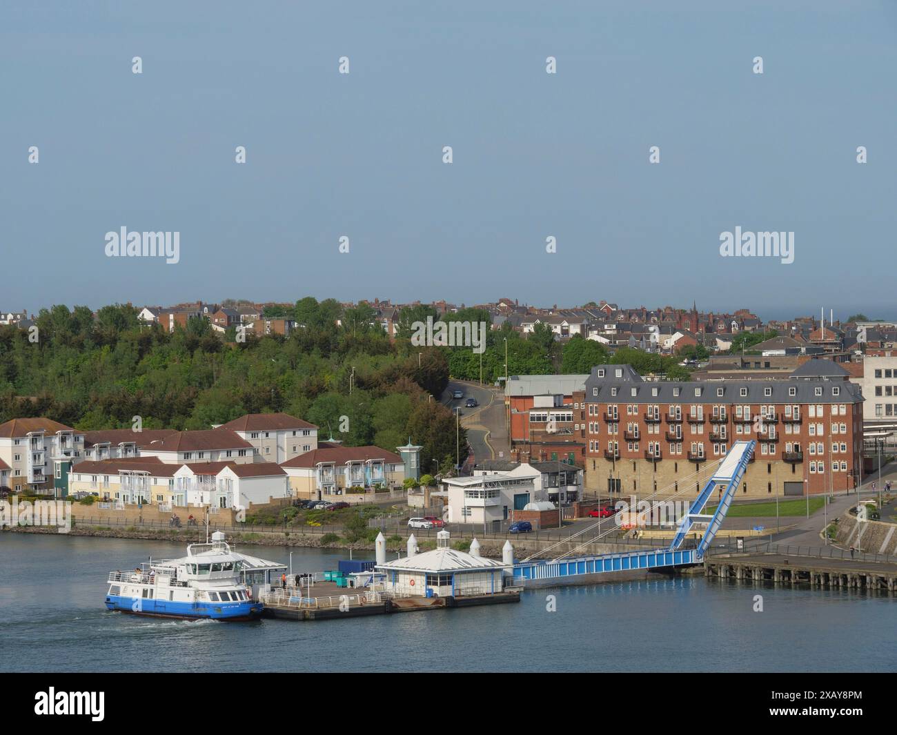 Area del porto con barche ed edifici moderni, circondata da vegetazione e sfondo urbano, tynemouth, Inghilterra, Gran Bretagna Foto Stock