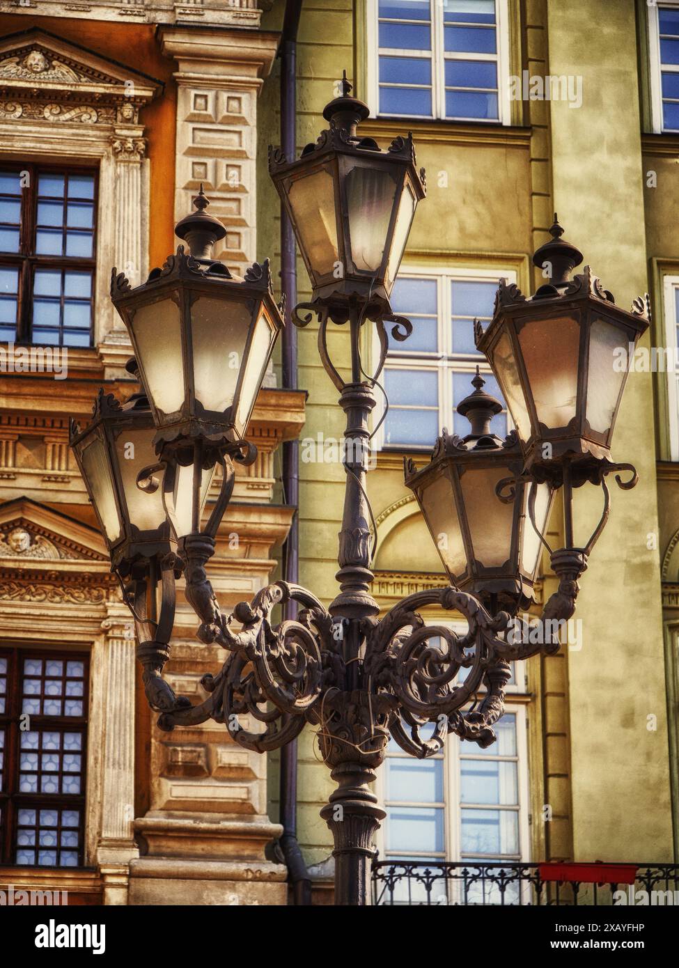 Eleganza urbana: Un lampione classico messo a fuoco contro edifici vibranti, che mette in risalto il fascino del patrimonio cittadino. Foto Stock