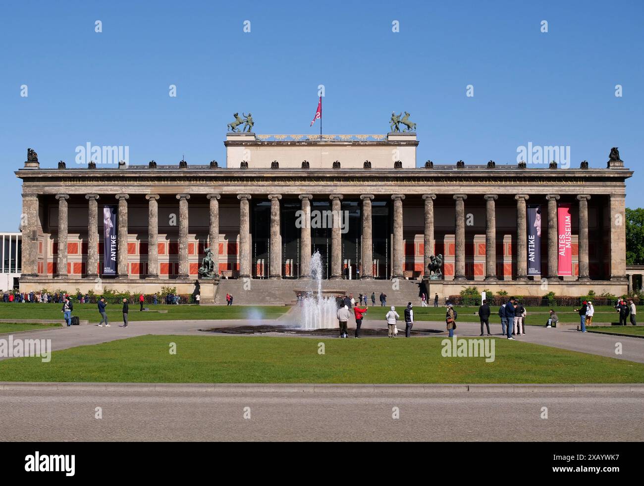 Berlino, Germania. 21 aprile 2024. 21.04.2024, Berlino. Vista del vecchio Museo del Lustgarten nel quartiere Mitte. In una soleggiata giornata di aprile, le persone scattano foto presso una fontana di fronte al museo. L'edificio classico di Karl Friedrich Schinkel fa parte dell'Isola dei Musei di Berlino. Ospita la collezione di antichità. Foto: Wolfram Steinberg/dpa credito: Wolfram Steinberg/dpa/Alamy Live News Foto Stock