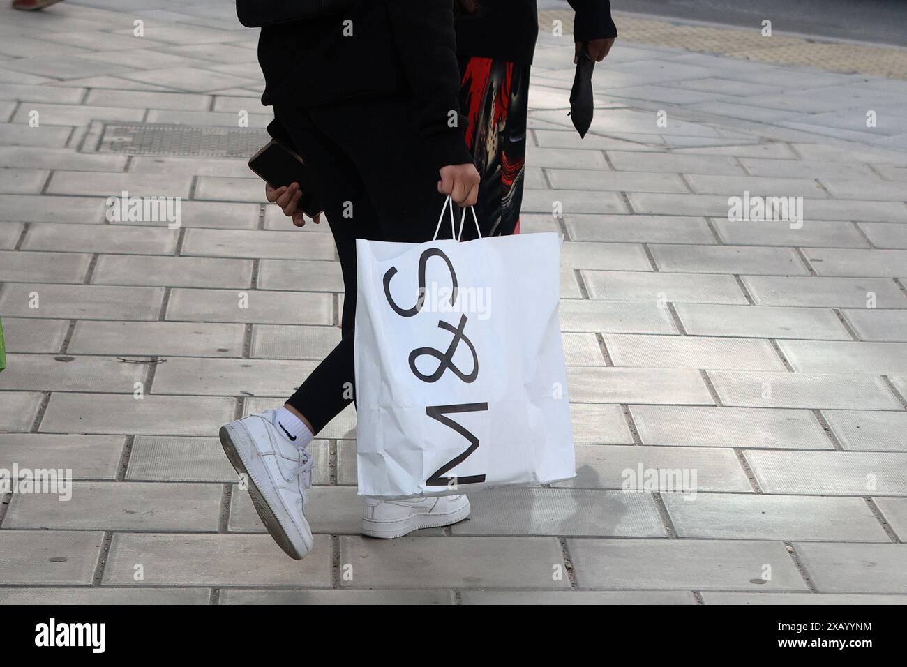 Un acquirente con un sacchetto di carta Marks & Spencer Foto Stock