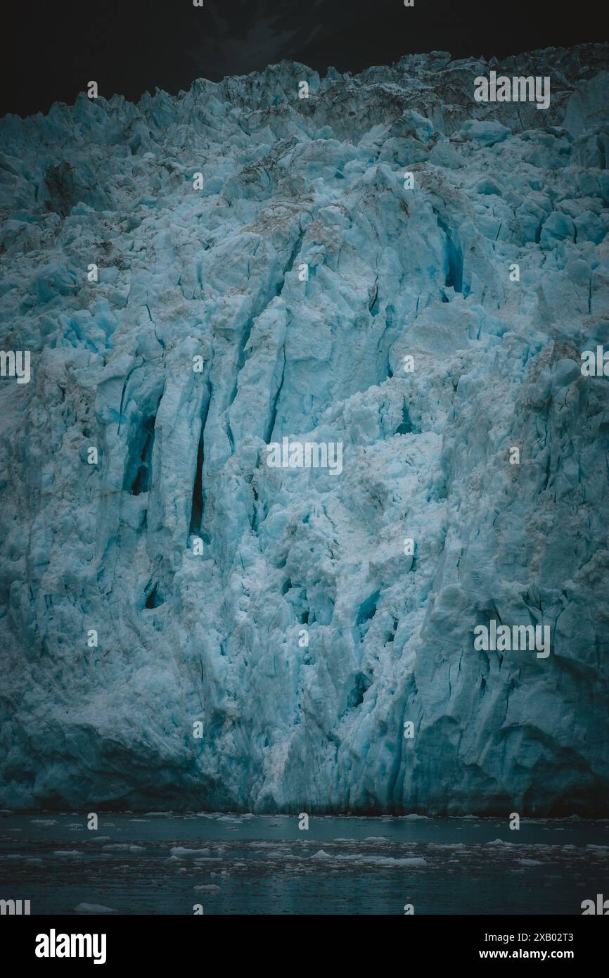 Osserva la maestosa potenza e la bellezza di un ghiacciaio dell'Alaska in questo incredibile primo piano, catturando i dettagli intricati e le ipnotiche tonalità blu Foto Stock