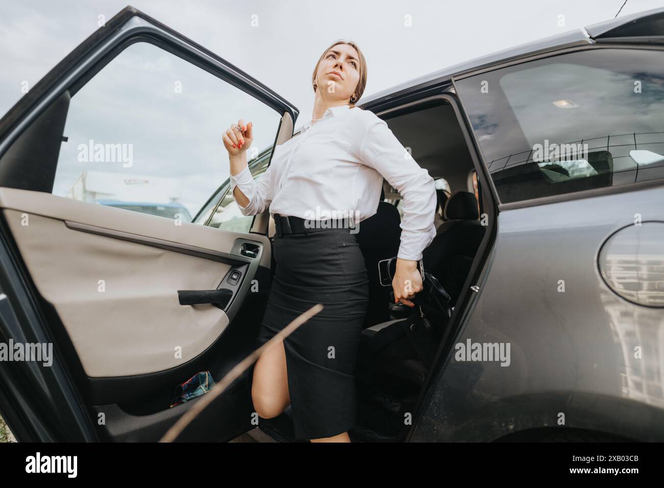 Donna d'affari sicura che esce dall'auto per una riunione all'aperto Foto Stock