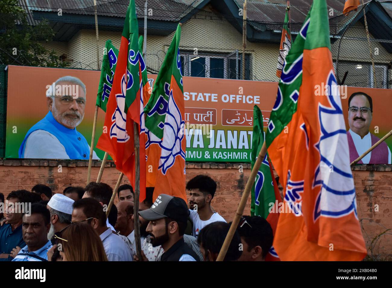 Srinagar, India. 9 giugno 2024. I sostenitori del Bharatiya Janata Party (BJP) tengono bandiere di partito mentre celebrano la cerimonia di giuramento di Narendra modi come primo ministro per il terzo mandato consecutivo a Srinagar. Narendra modi, leader del Partito nazionalista indù Bharatiya Janata (BJP), ha prestato giuramento come primo ministro indiano per la terza volta. La cerimonia si è svolta a Rashtrapati Bhavan, nella capitale indiana nuova Delhi. Il leader di 73 anni è solo il secondo primo ministro indiano a mantenere il potere per un terzo mandato. Credito: SOPA Images Limited/Alamy Live News Foto Stock