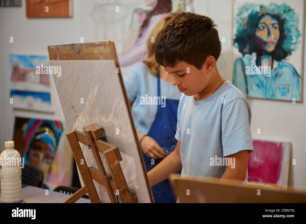 I bambini hanno lezioni d'arte, disegno, pittura con l'insegnante in laboratorio. Ambiente creativo che promuove le competenze artistiche e l'istruzione. Foto Stock