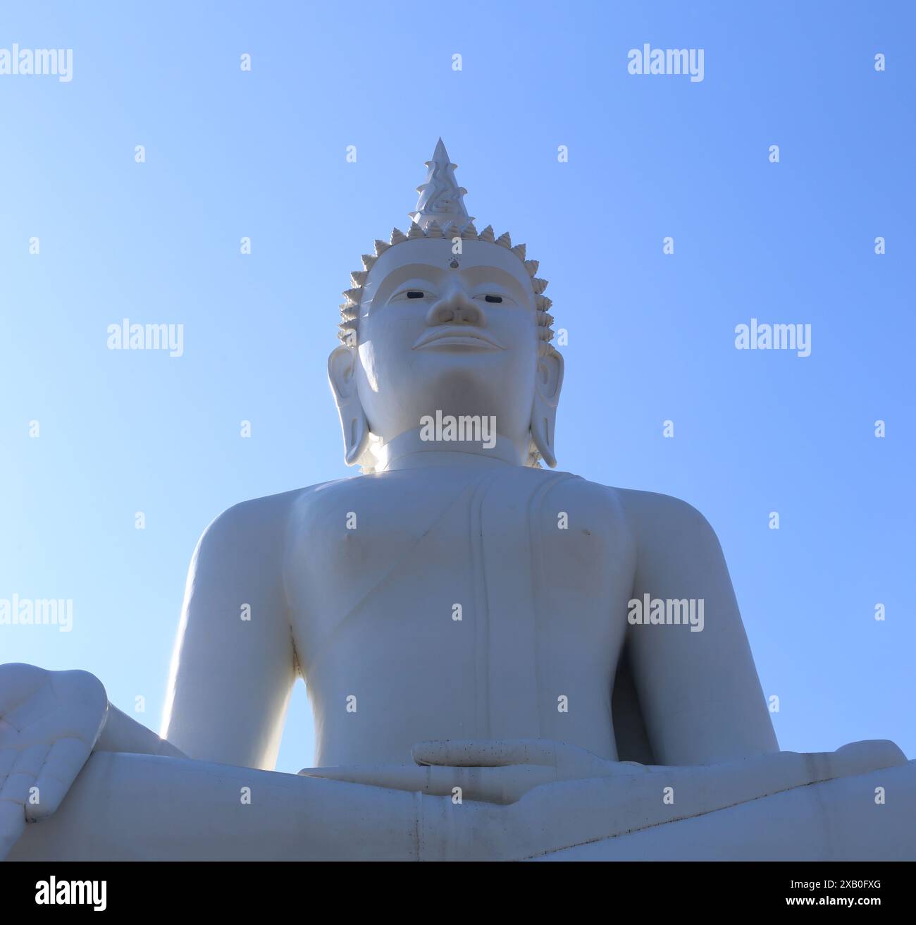 Di fronte alla grande statua di Buddha sullo sfondo blu del cielo, statua del Buddha bianco nel buddismo. Foto Stock