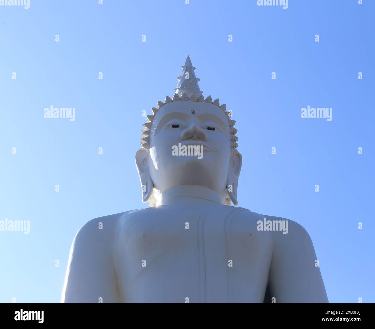 Di fronte alla grande statua di Buddha sullo sfondo blu del cielo, statua del Buddha bianco nel buddismo. Foto Stock