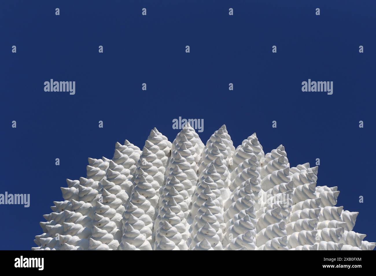 La parte superiore della grande statua bianca del Buddha sullo sfondo blu del cielo, statua del Buddha bianco nel buddismo. Foto Stock