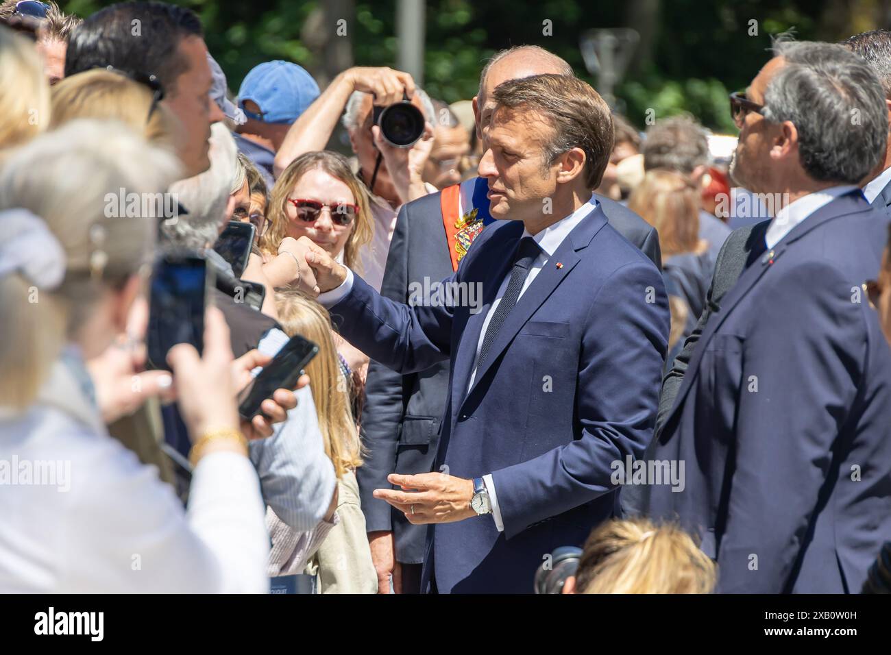 Le Touquet. 9 giugno 2024. Il presidente francese Emmanuel Macron (2° R) saluta i residenti al di fuori di un seggio elettorale al suo arrivo per votare per le elezioni del Parlamento europeo a le Touquet, in Francia, il 9 giugno 2024. Macron ha annunciato lo scioglimento dell'Assemblea nazionale e ha indetto nuove elezioni legislative domenica sera dopo che il suo partito rinascimentale ha subito una pesante sconfitta alle elezioni del Parlamento europeo (EP), secondo una trasmissione in diretta dei media locali BFMTV. Crediti: Frank Boham/Xinhua/Alamy Live News Foto Stock