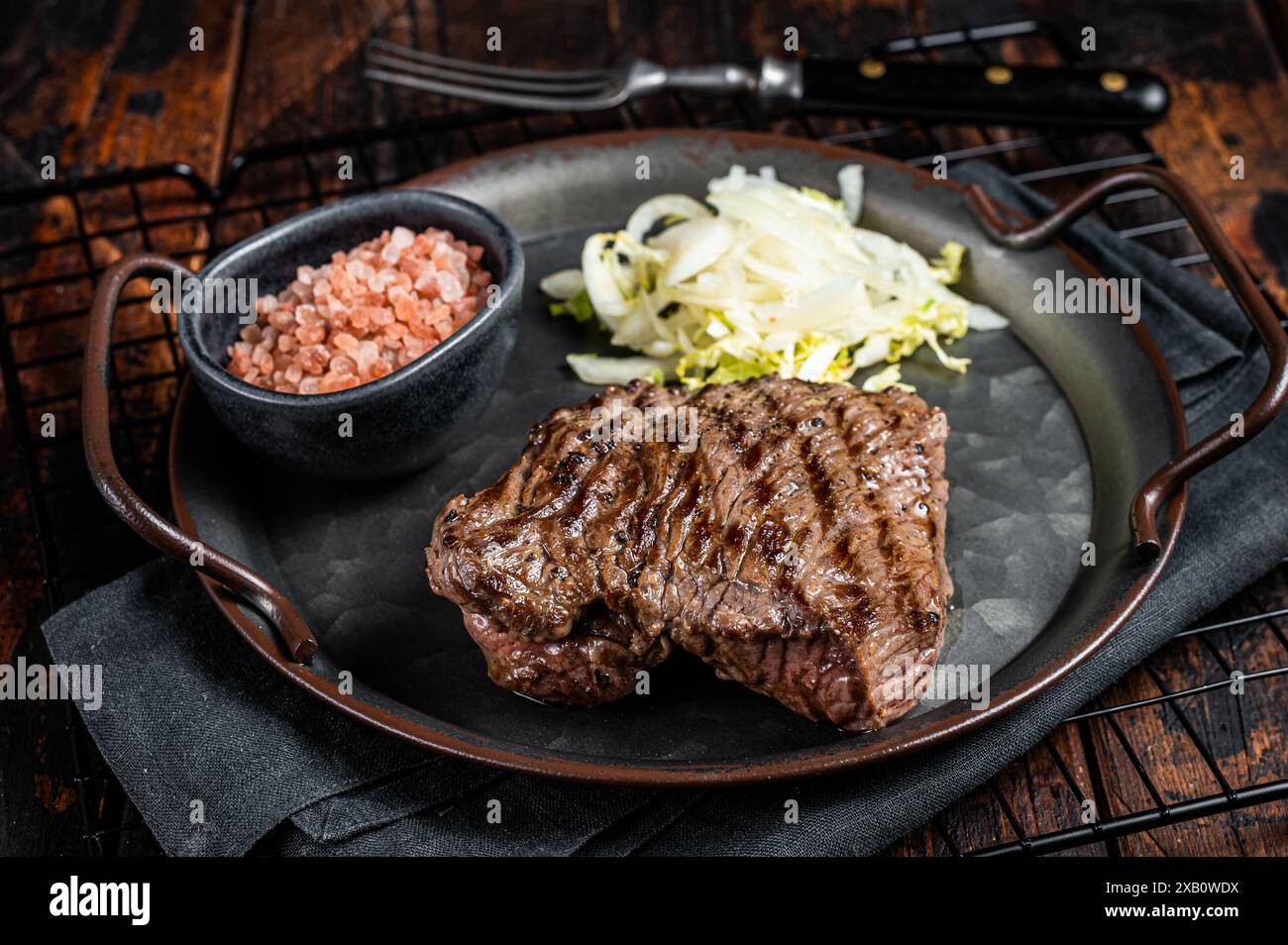 Bistecca di cervo con sale marino e insalata. Sfondo di legno. Vista dall'alto. Foto Stock