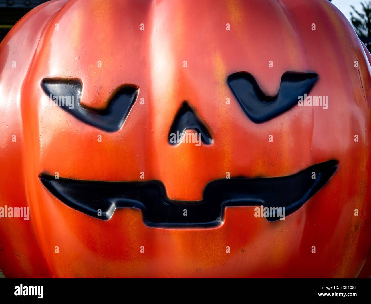 Ritratto ravvicinato della zucca Halloween Jack o Lanterna con un volto spaventoso, materiale in resina, vernice spray con aerografo. Faccia di zucca rossa grassa. Felice Hallo Foto Stock