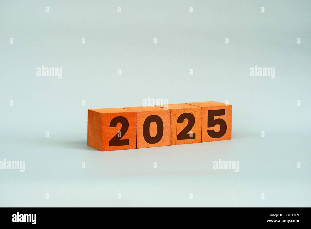 Cubi di legno con numeri 2025 su un tavolo su sfondo bianco. Pianificazione aziendale nel 2025 Foto Stock