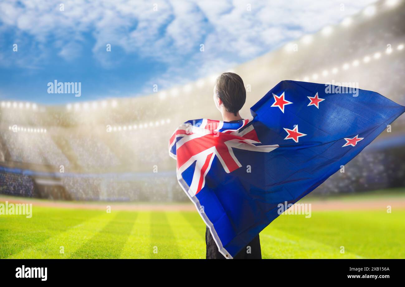 Tifoso neozelandese allo stadio di cricket o di rugby. Tifoso neozelandese sul campo da calcio, che guarda le partite della squadra di calcio. Sostenitori con bandiera Foto Stock
