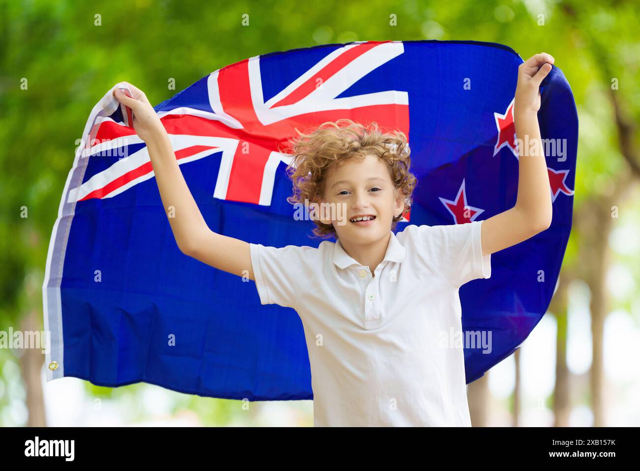 Bambino che corre con la bandiera della nuova Zelanda. Il piccolo neozelandese tifo per la squadra di campagna. I tifosi Kiwi sul campo sportivo guardano le partite di squadra. Foto Stock