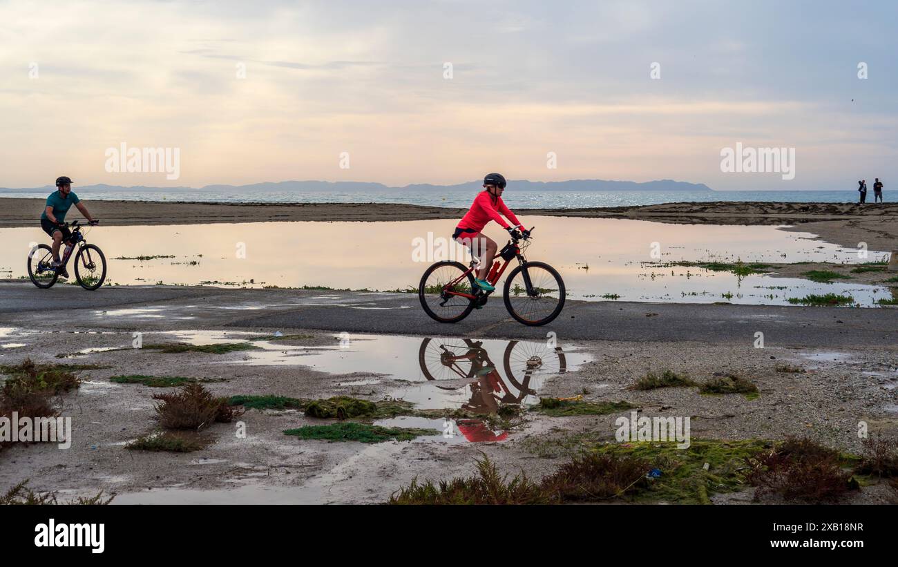 Roquetas de Mar, Almería, Spagna. 19/04/2024. Atleti che pedalano lungo la spiaggia di Roquetas de Mar all'alba. Foto Stock