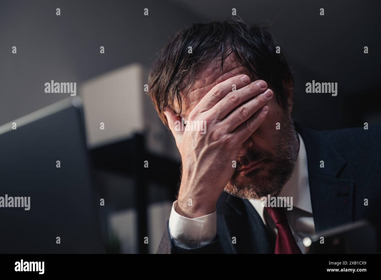 Imprenditore in bancarotta che copre la faccia con mano in ufficio, concetto di fallimento aziendale, attenzione selettiva Foto Stock