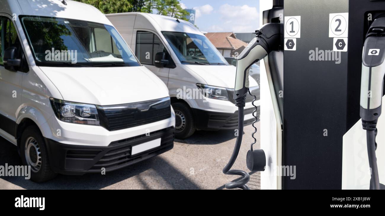 Furgoni elettrici con stazione di ricarica per veicoli elettrici. Foto Stock