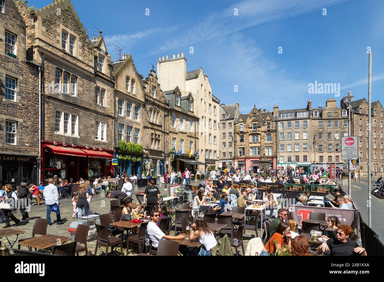 Persone che si godono una giornata di sole al Grassmarket, alla città vecchia, a Edimburgo Foto Stock