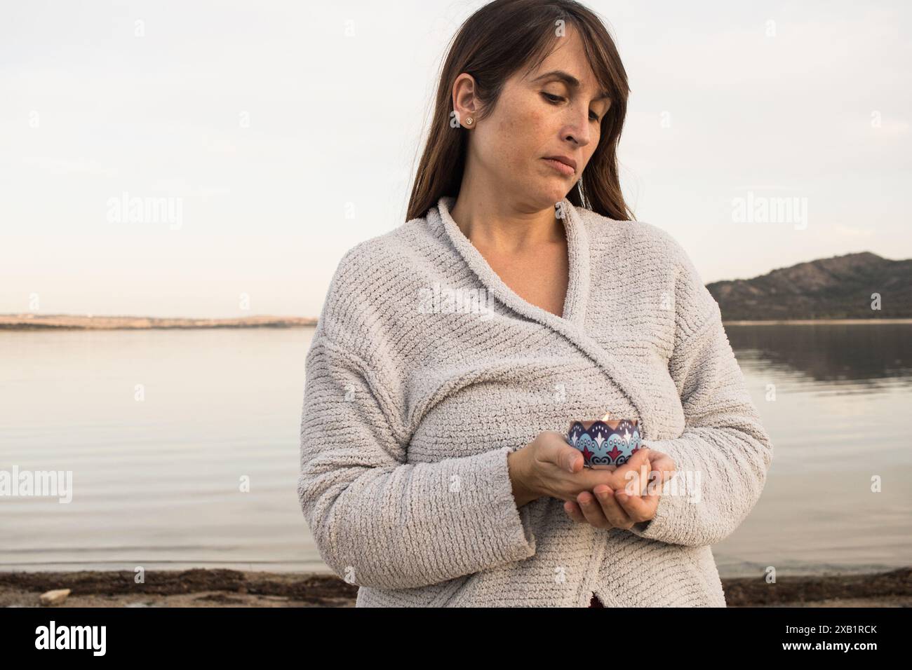 donna di bellezza che tiene in mano una candela blu. Meditazione. Relax. aromaterapia. concetto. Orizzontale Foto Stock