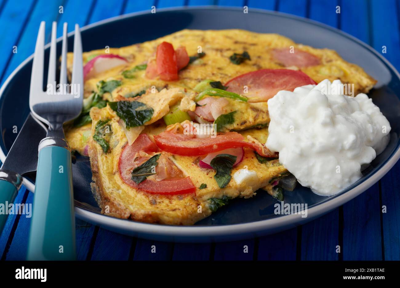 Omelette di funghi e pomodoro con una porzione di formaggio fresco. Foto Stock