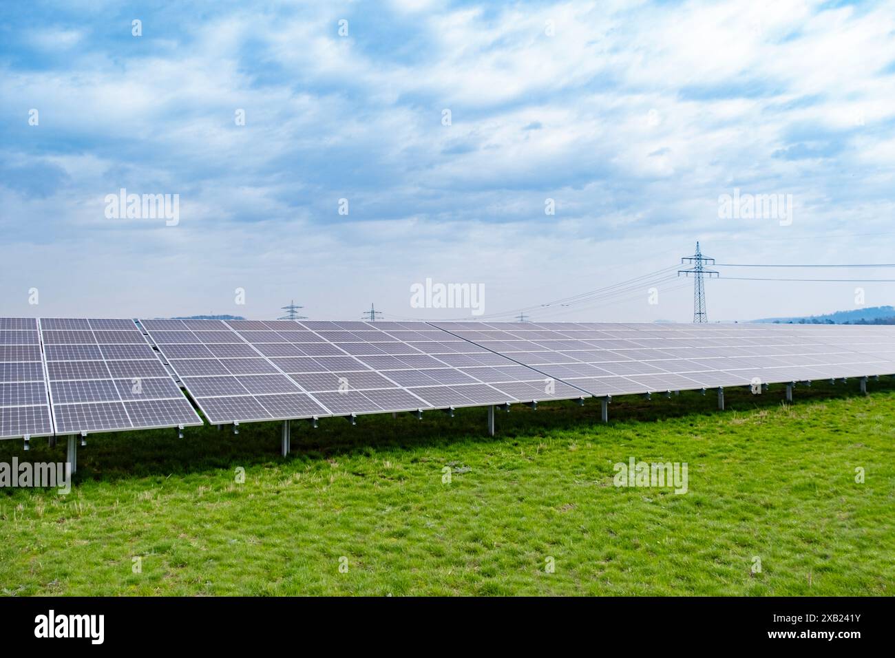 Le file di pannelli fotovoltaici si estendono attraverso le fattorie solari, catturando l'energia solare per un futuro sostenibile, l'energia pulita delle fattorie solari, generando elettricità fr Foto Stock