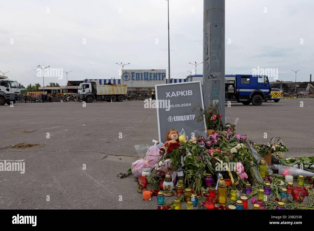 Fiori e tributi presso il negozio dell'epicentro K a Charkiv dopo che le bombe guidate russe UMPB D30-SN hanno colpito il negozio, uccidendo 19 persone. Maggio 2024 Foto Stock