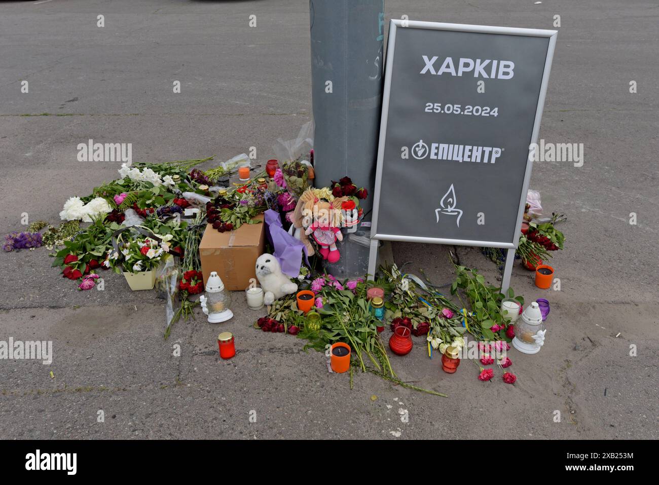 Fiori e tributi presso il negozio dell'epicentro K a Charkiv dopo che le bombe guidate russe UMPB D30-SN hanno colpito il negozio, uccidendo 19 persone. Maggio 2024 Foto Stock
