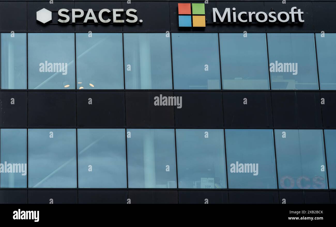 Amsterdam, Paesi Bassi, 09.06.2024, Logos dell'azienda tecnologica Microsoft e agenzia di noleggio Spaces nell'edificio per uffici dell'aeroporto di Schiphol Foto Stock