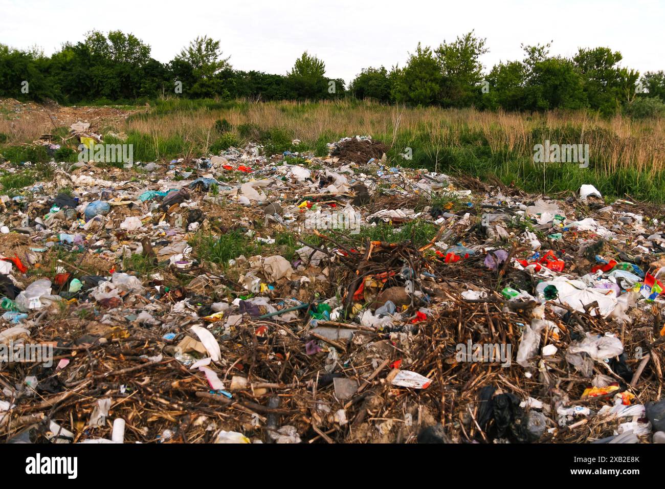 Una discarica con rifiuti e detriti sullo sfondo. Inquinamento ambientale causato dai rifiuti delle discariche. Rifiuti e detriti sullo sfondo di una discarica Foto Stock