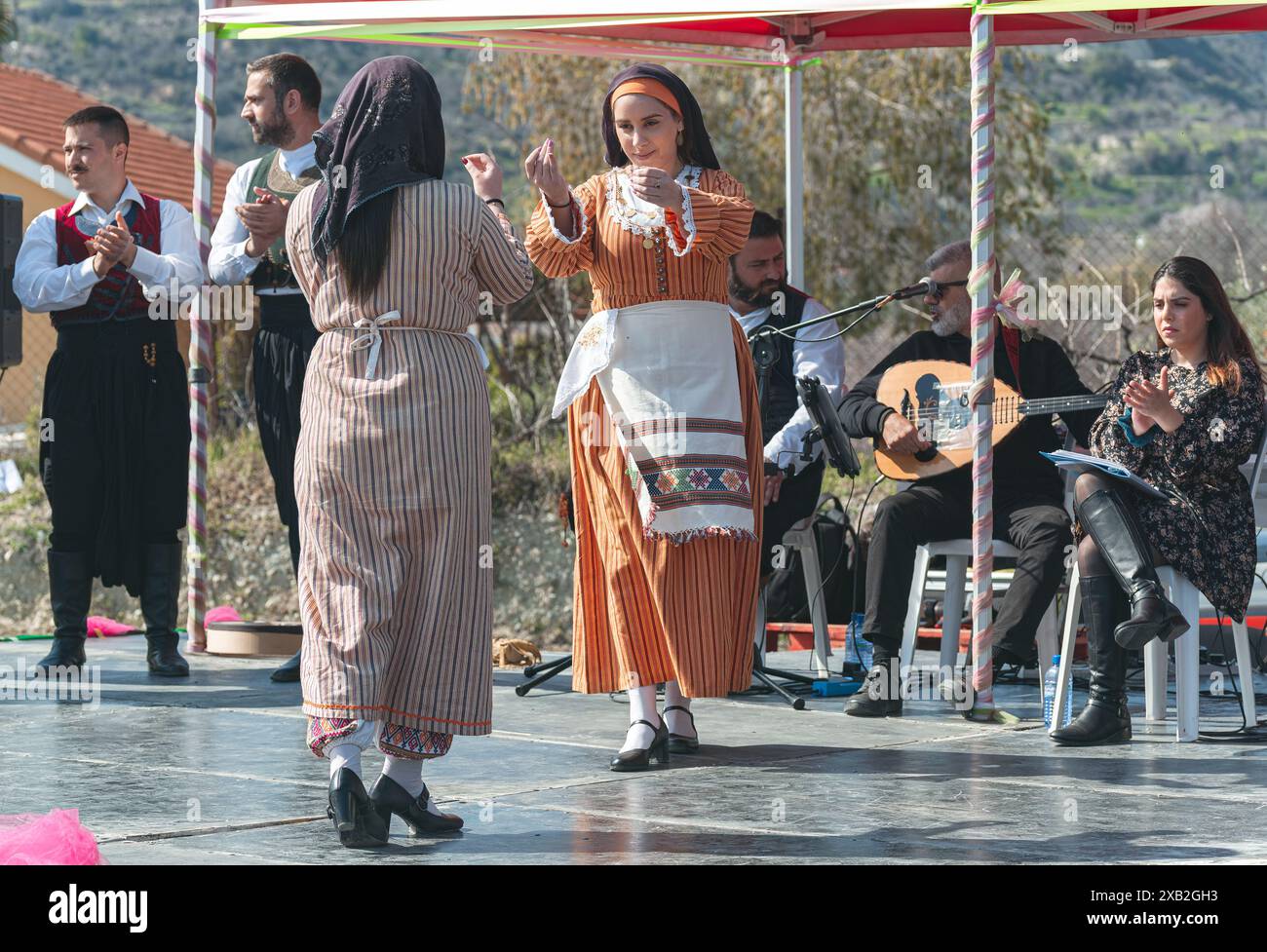 Limnatis, Cipro - 24 dicembre 2022: Ballerini ciprioti tradizionali che si esibiscono con musicisti che suonano all'Almond Tree Blossom Festival Foto Stock