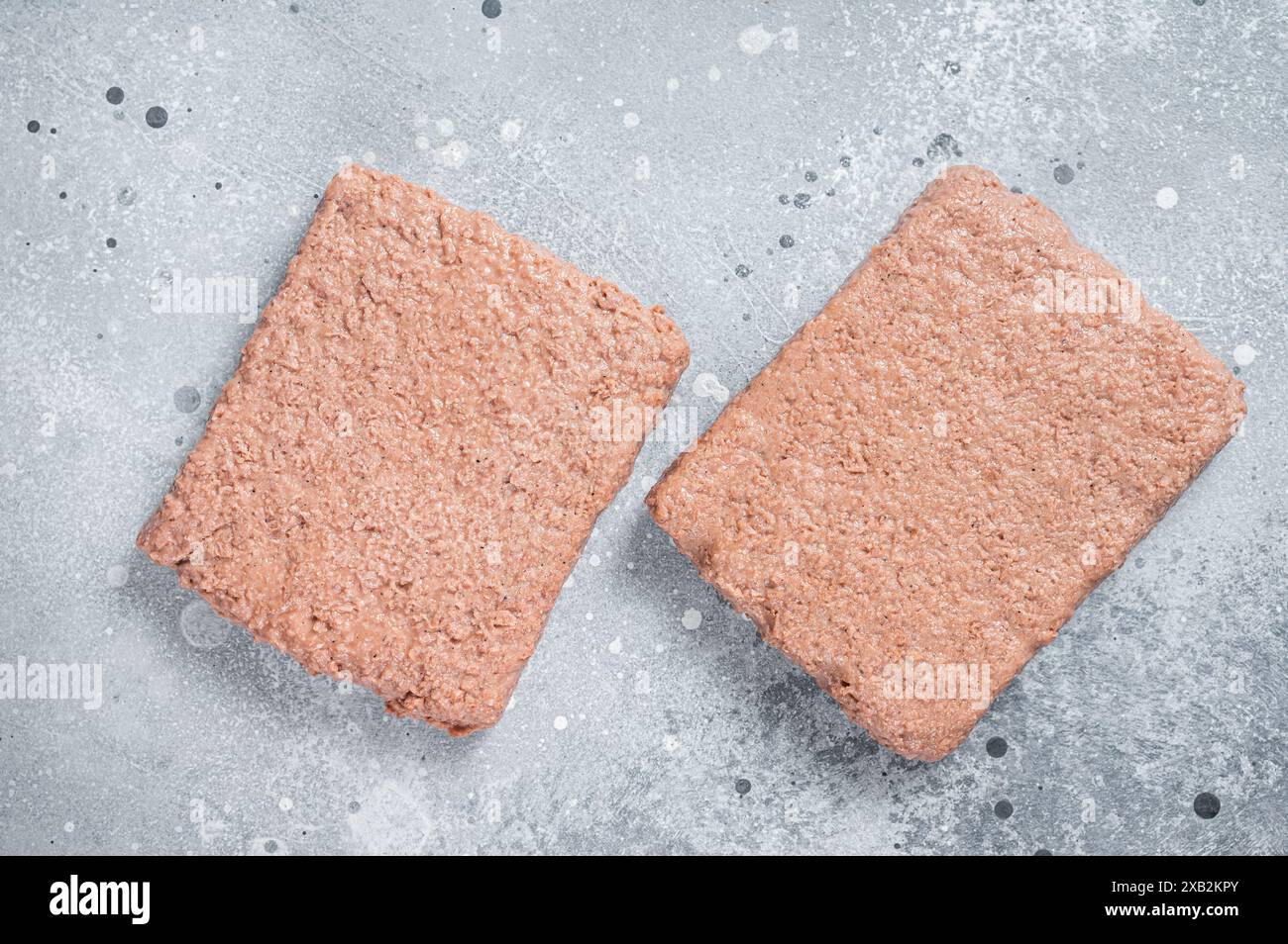 La carne a base di piante crude, gli alimenti riducono l'impronta di carbonio. Sfondo grigio. Vista dall'alto. Foto Stock