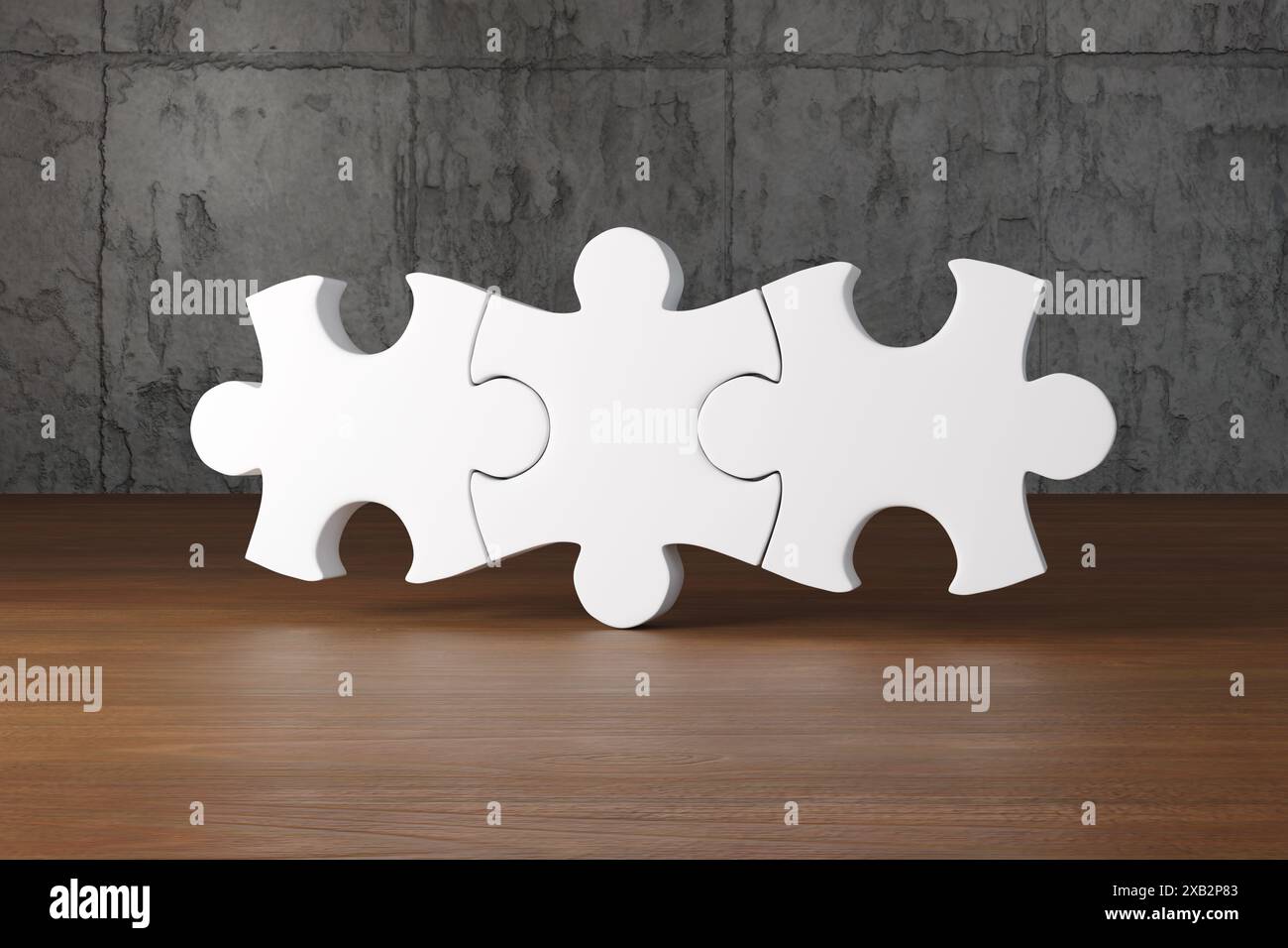 3 puzzle bianchi collegati su un tavolo di legno di fronte a una parete di ardesia in cemento. Concetto di abbinamento perfetto, connessione, lavoro di squadra e cooperazione Foto Stock
