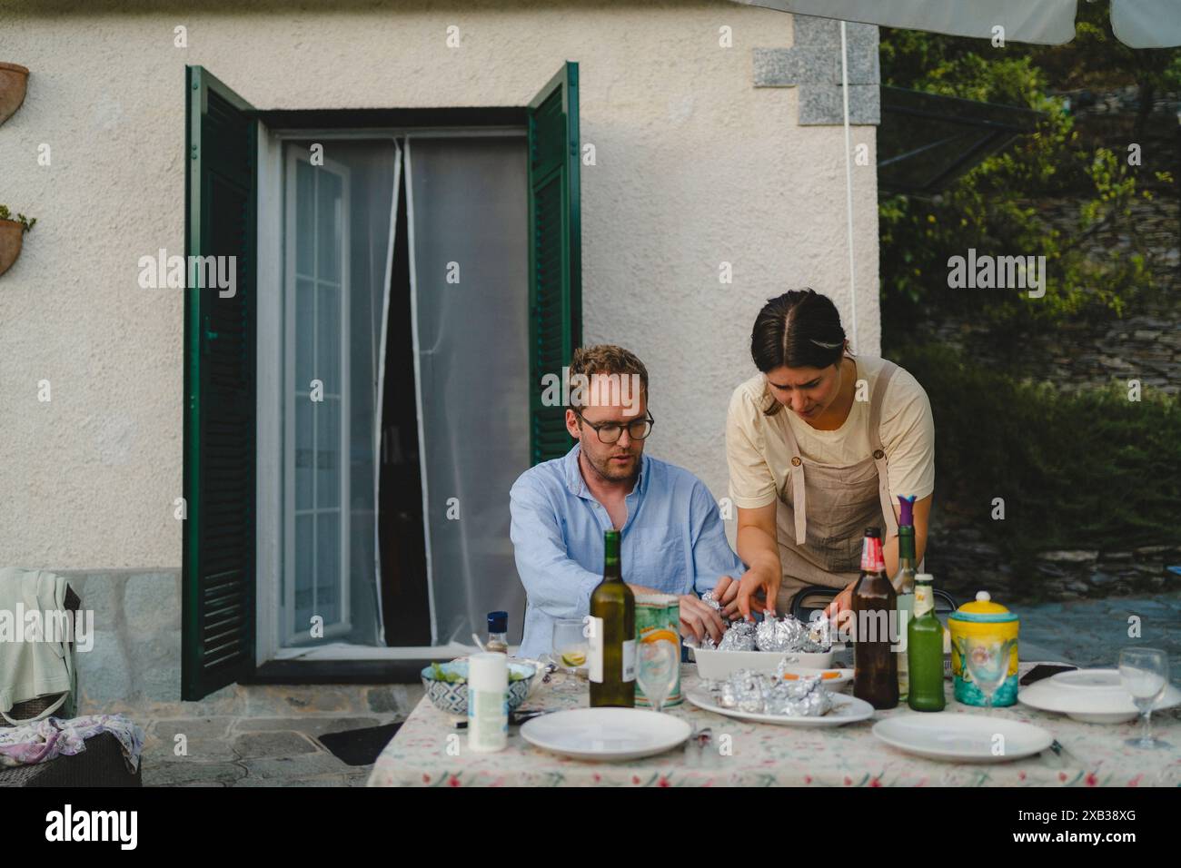 Amici maschi e femmine che mangiano nel cortile posteriore Foto Stock