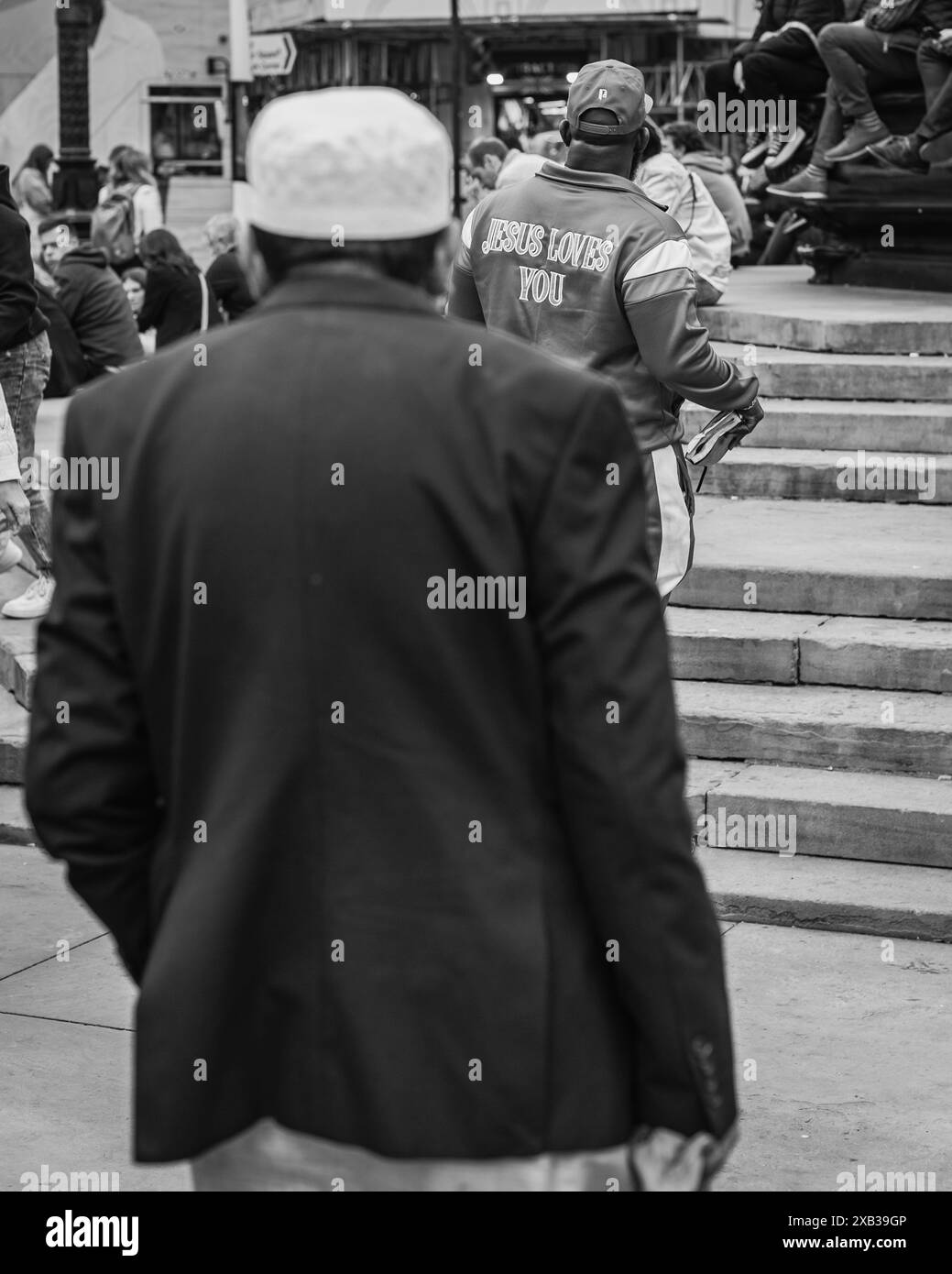 Un uomo musulmano guarda un cristiano predicare Piccadilly, Londra. Foto Stock