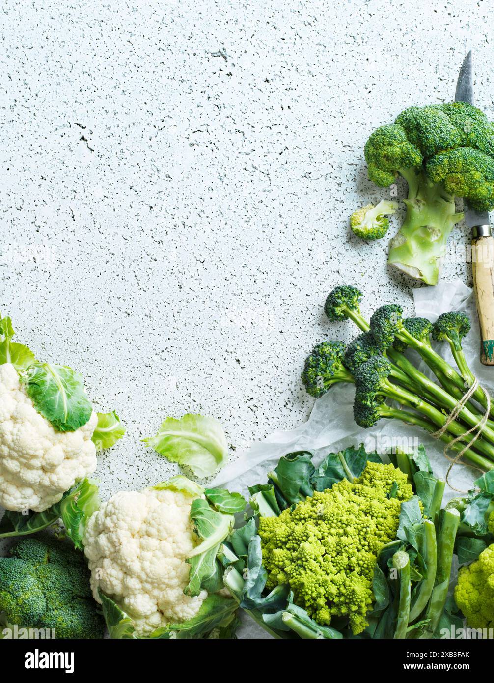 Broccoli e vari cavolfiori tenuti su tavola bianca Foto Stock