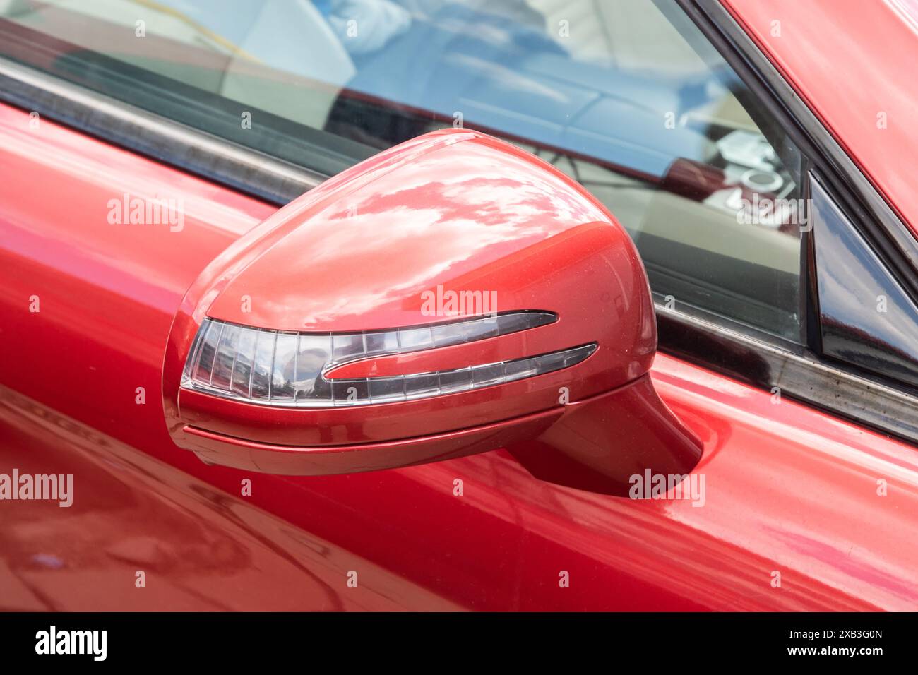 Specchio laterale del primo piano di un'auto rossa di lusso Foto Stock
