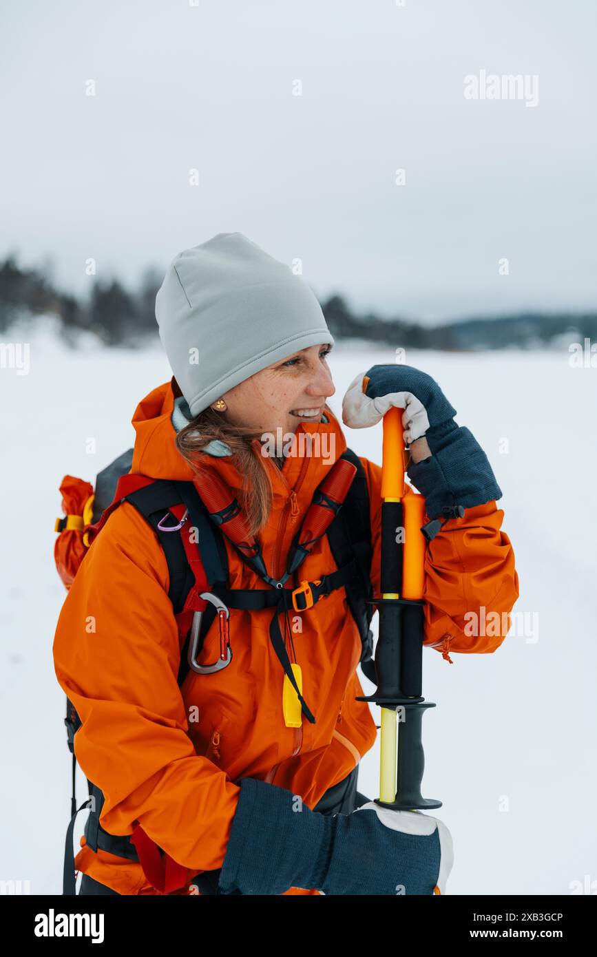 Donna felice con i bastoncini da trekking in inverno Foto Stock