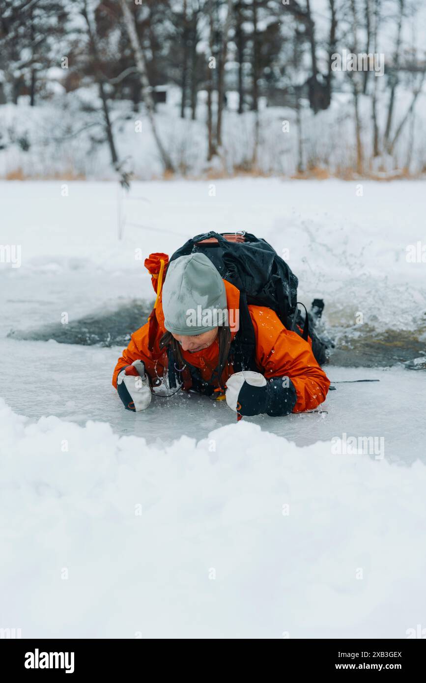 Donna che prende e esce dall'acqua del lago ghiacciata Foto Stock