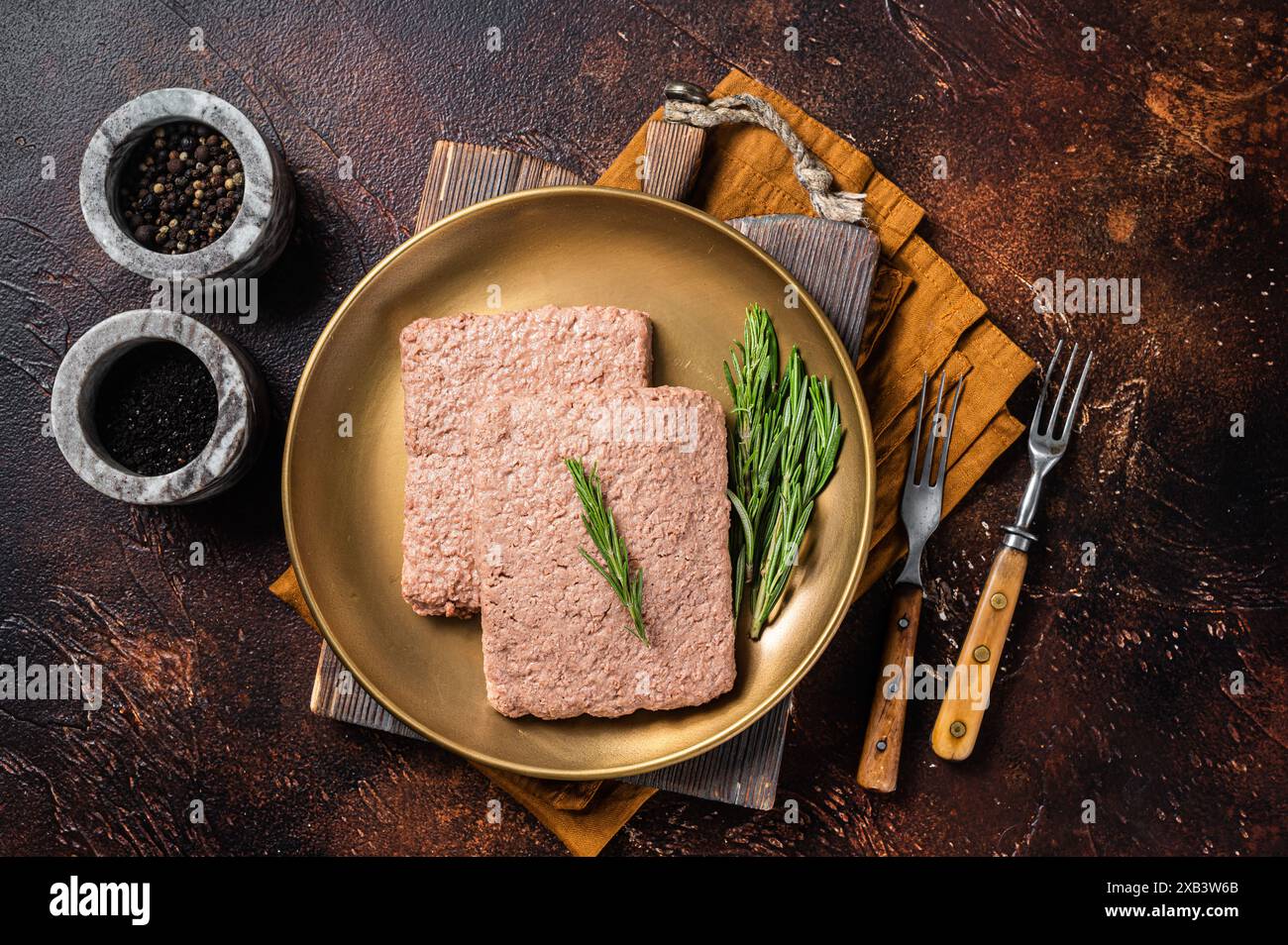 Carne di macina Veggie fresca, carne a base di piante crude con rosmarino. Sfondo scuro. Vista dall'alto. Foto Stock