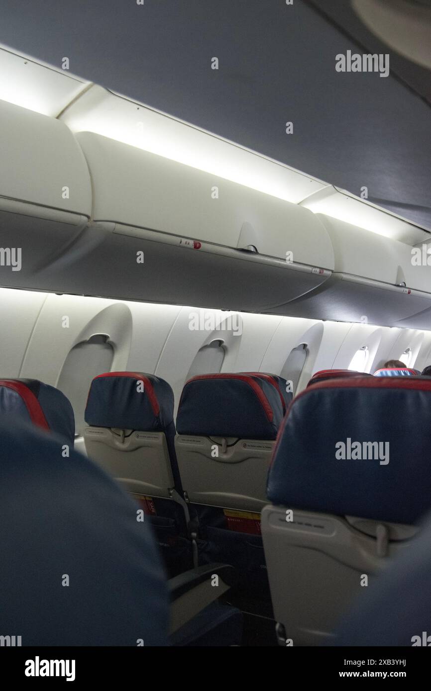 Sedili per aeroplani Economy con vano portaoggetti superiore. Foto Stock
