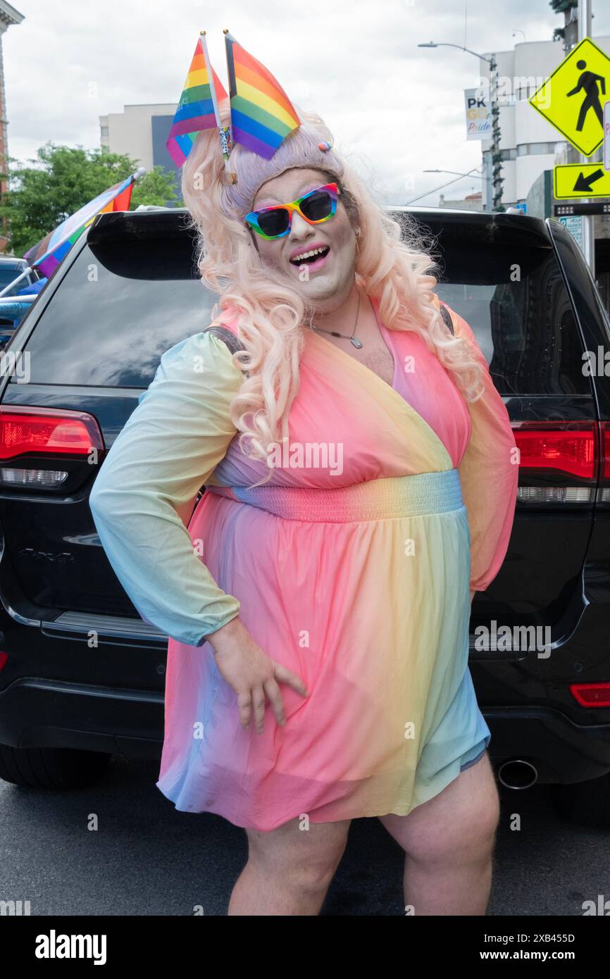 Un interprete di drag in un abito colorato che indossa 2 bandiere LGBTQ+ nei capelli. Alla Poughkeepsie Pride Parade nella Hudson Valley, New York. Foto Stock