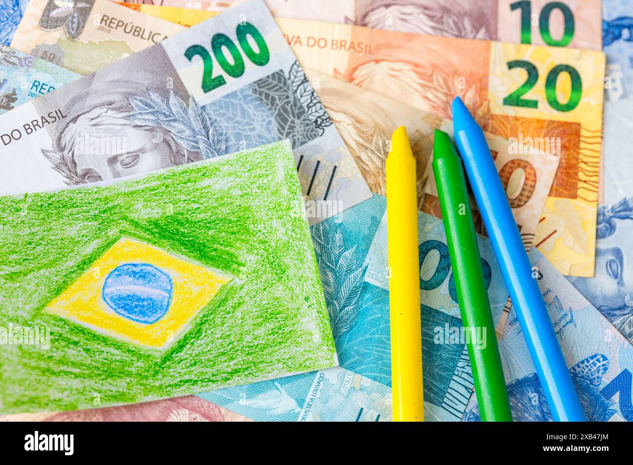 Brasile Money, educazione finanziaria dei più giovani, imparare a gestire il denaro con saggezza, concetto, bandiera brasiliana e banconote reais dipinte a mano con cray Foto Stock