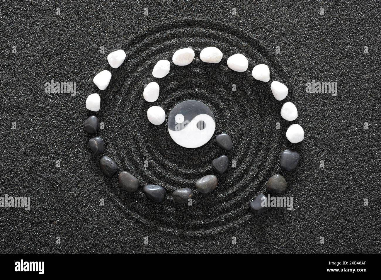 Japanischer ZEN Garten in schwarzem Sand Japanischer ZEN Garten der Ruhe und Entspannung mit Yin Yang Stein in strukturiertem Sand *** Japanese ZEN ga Foto Stock