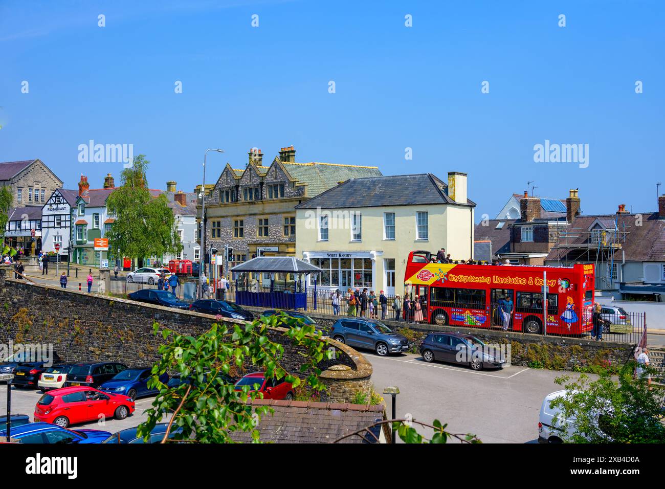 Conwy Wales Regno Unito 06-01-2024. Vista panoramica di una città in una giornata di sole con un autobus turistico a due piani ed edifici storici. Foto Stock