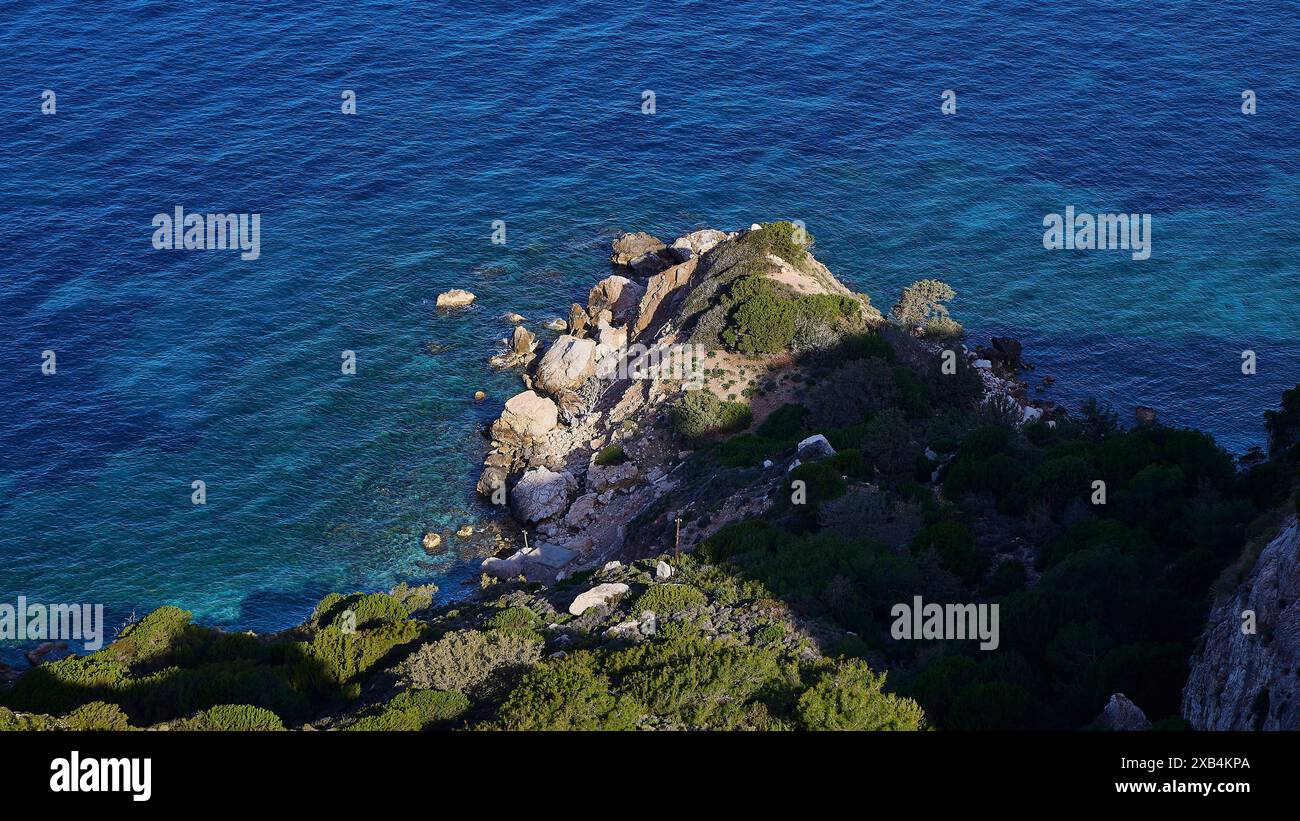 Vista dall'alto della costa rocciosa dove il mare blu incontra le scogliere, circondato da vegetazione verde, il castello di Kritinia e il castello di San Giovanni Foto Stock