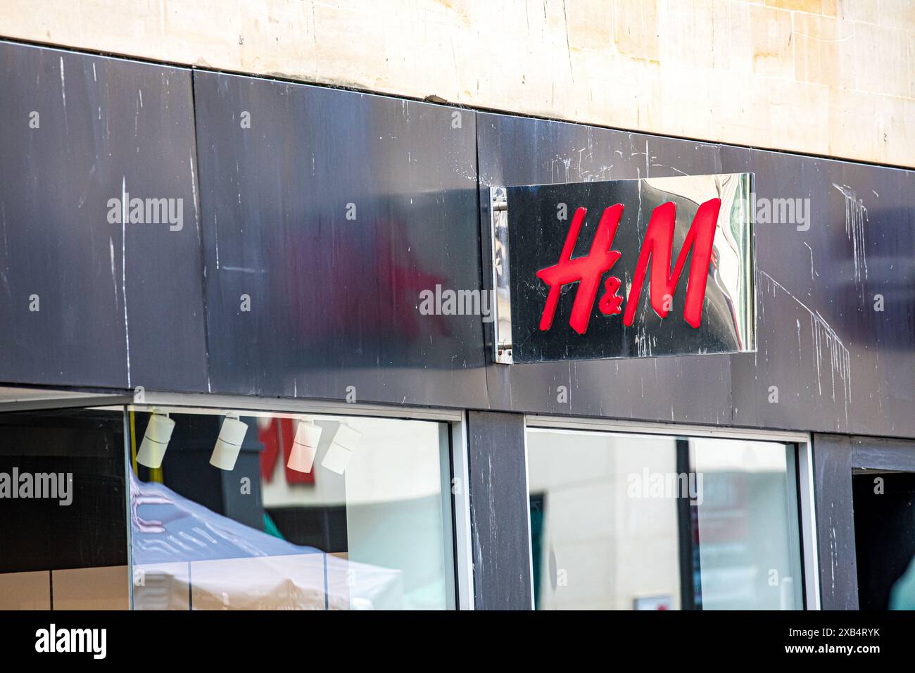 Cartellonistica, branding, logo e facciata del negozio di fronte a H&M. Foto Stock