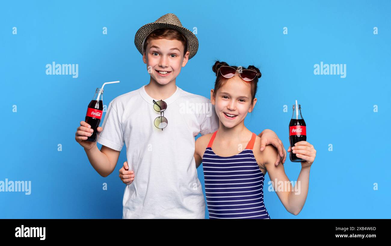 Piccolo Ragazzo e ragazza bere Coca-Cola classica con cannucce Foto Stock