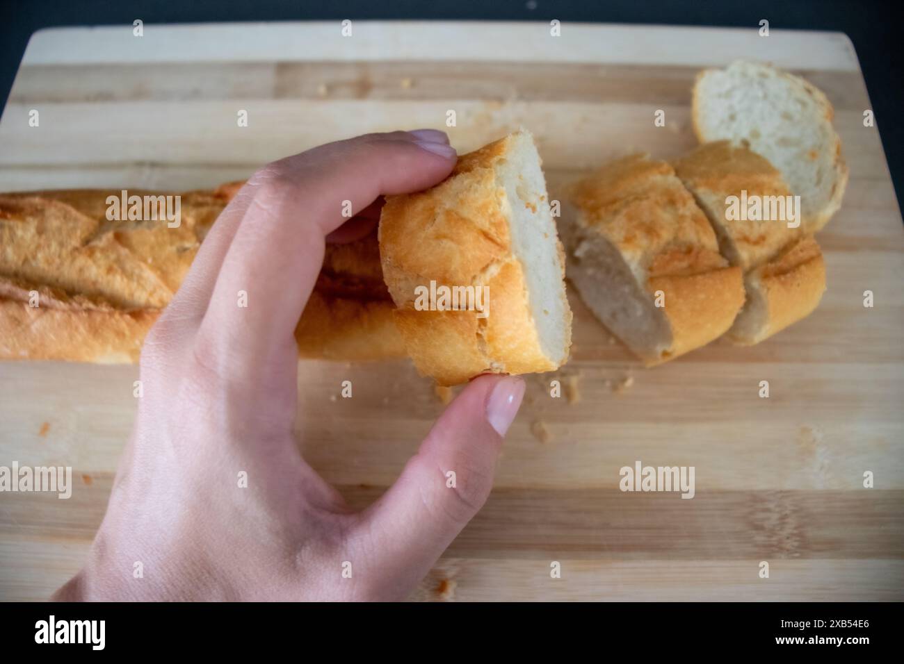 Affettare il pane su una tavola di legno e fare una deliziosa colazione Foto Stock